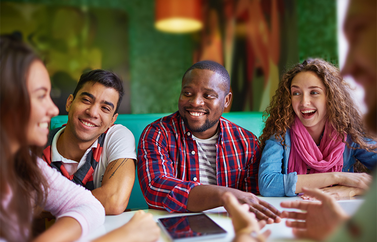 Photo of four young adult students chatting with each other