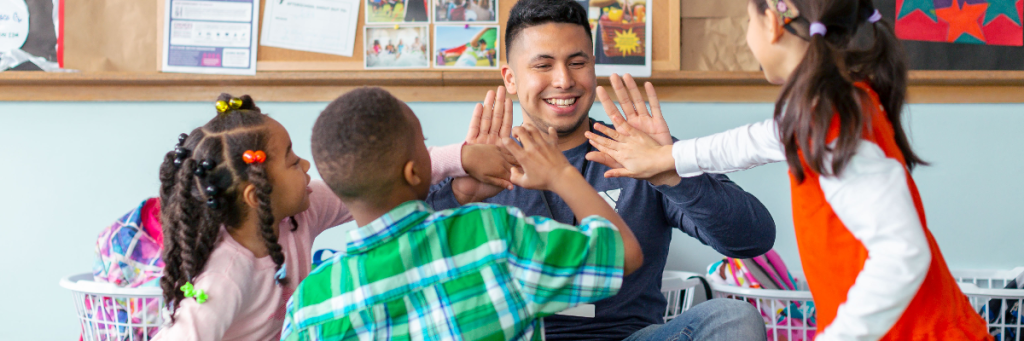 YMCA staff member giving a high-five to youth members