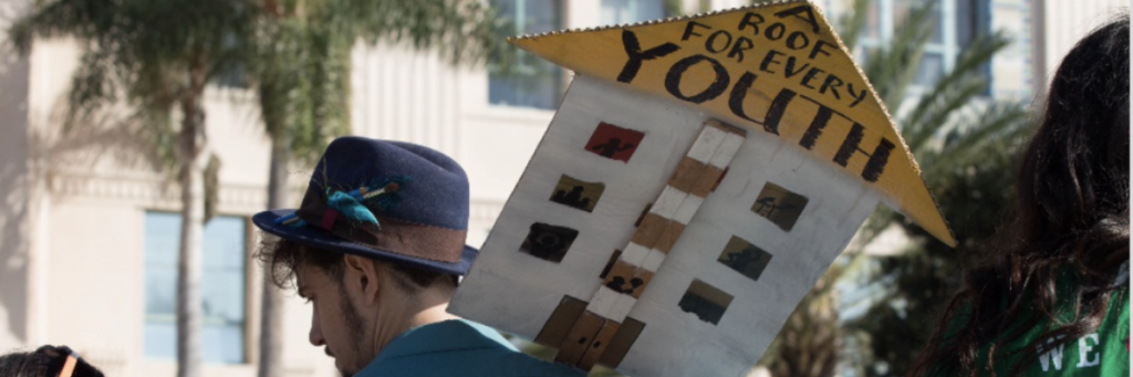 man with youth house sign