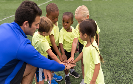 Photo of a coach with his players on a team cheer