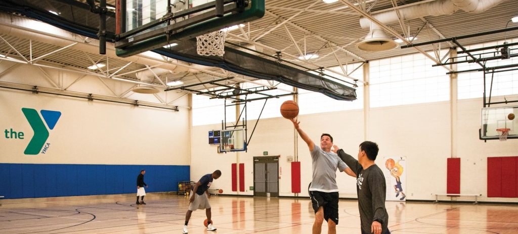 Men playing indoor basketball at the YMCA