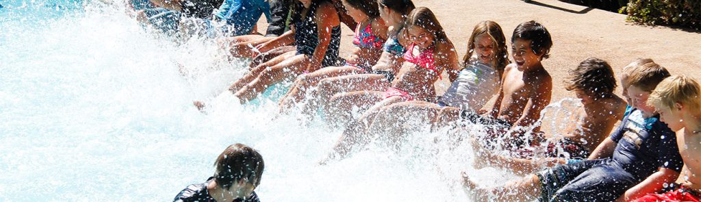 Kids kicking water at the swimming pool