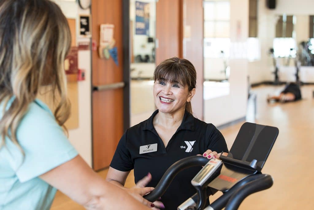 trainer showing member how to use cardio machine