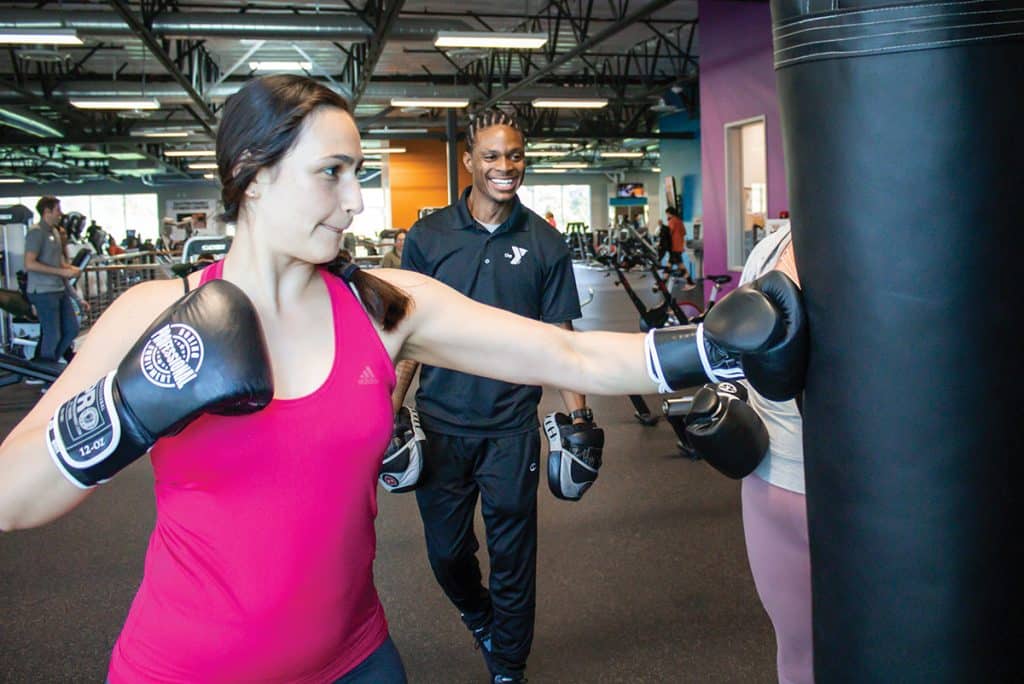 woman boxing while personal trainer observes