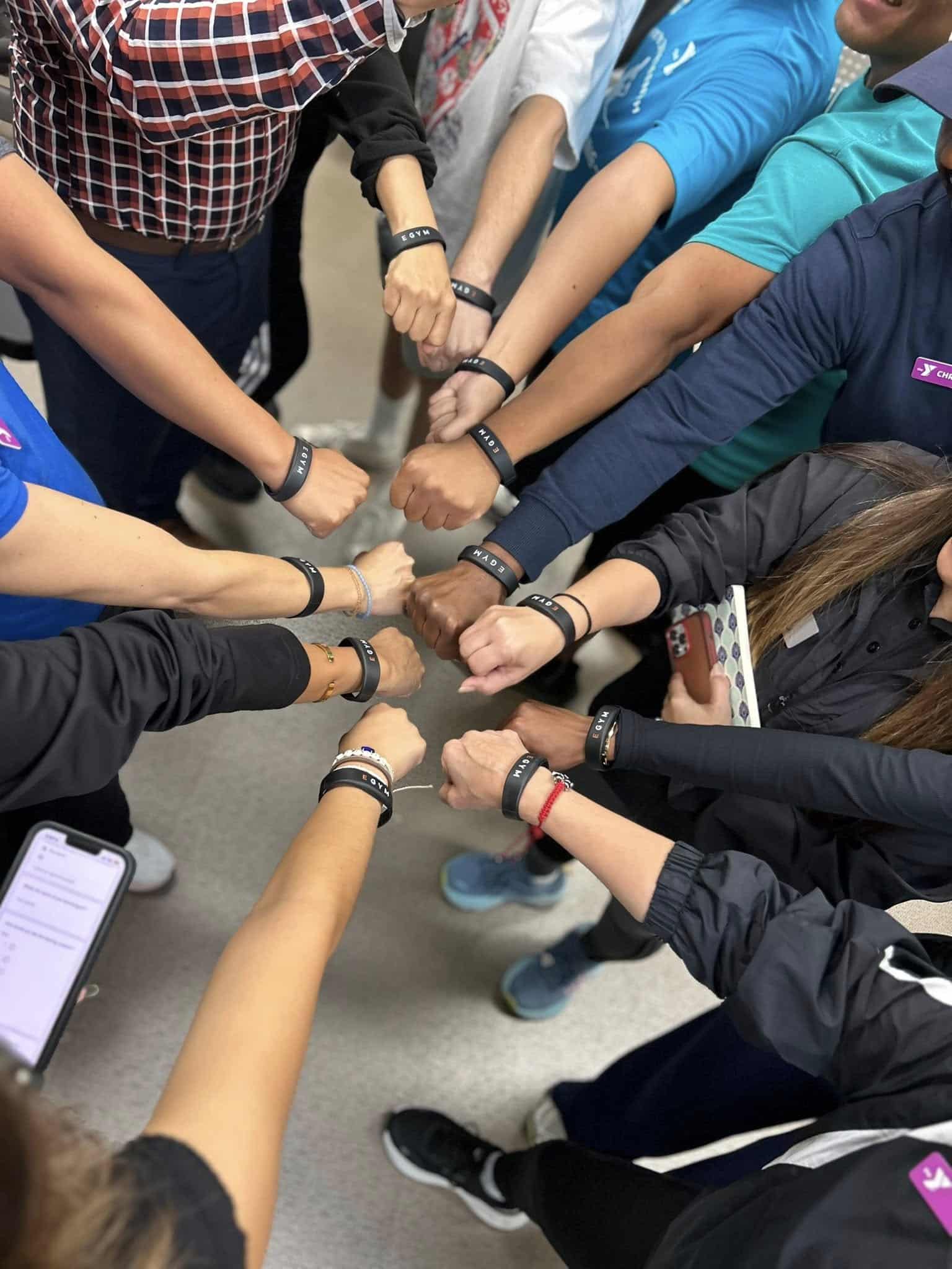 hands in circle with egym wristbands