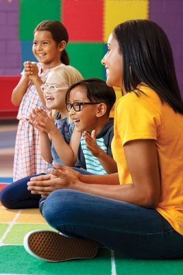AC Web 450x674l kids smiling with teacher